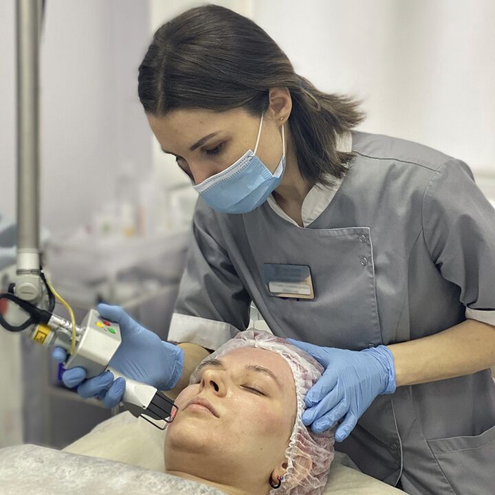 Una cosmetóloga realiza un procedimiento de rejuvenecimiento facial de la piel con láser fraccionado